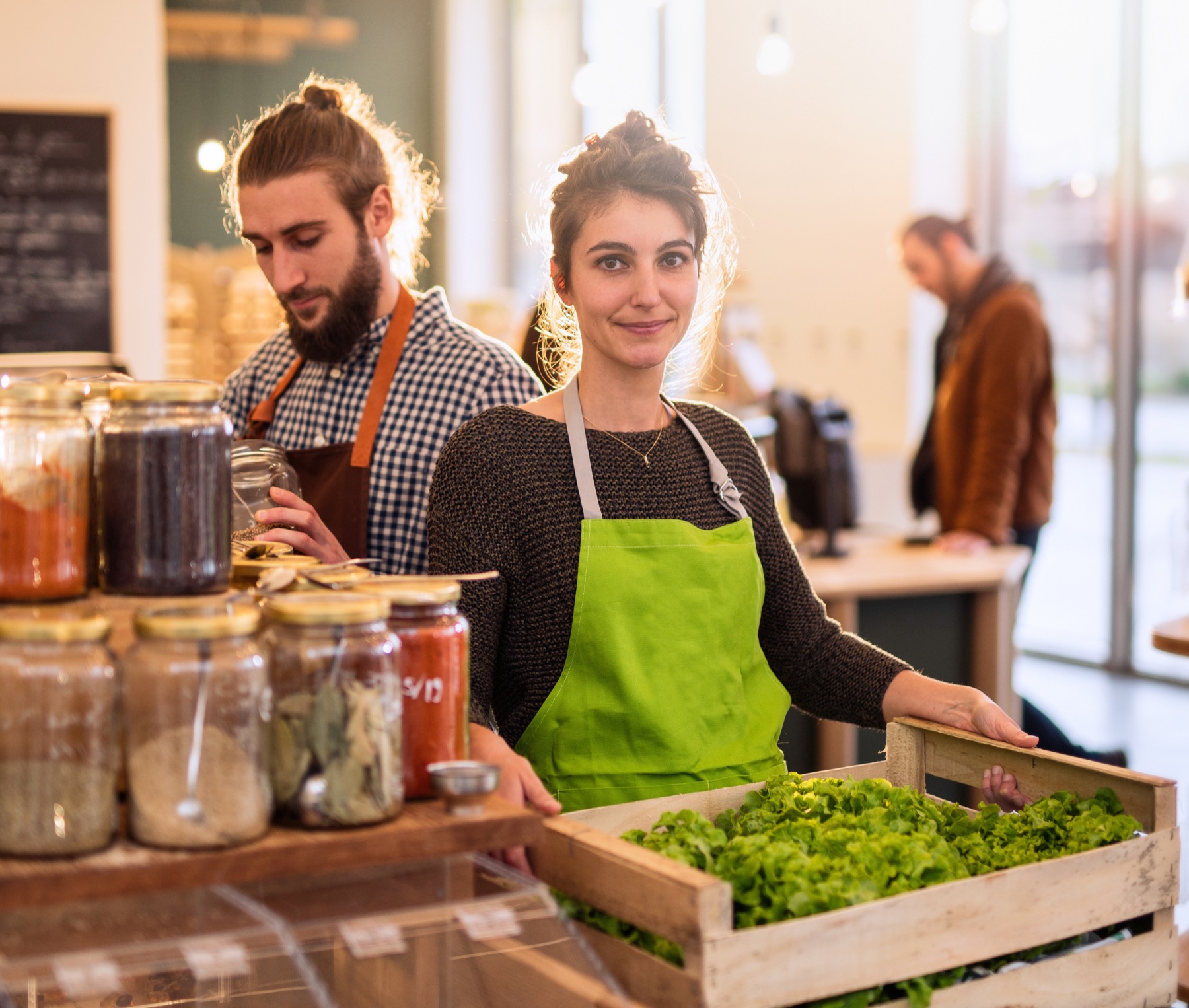 Small business owner in a green apron at a cafe